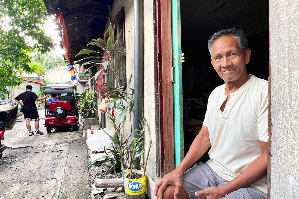 A former prisoner in the Philippines sits in a doorway after being released from incarceration through a UN-supported programme.