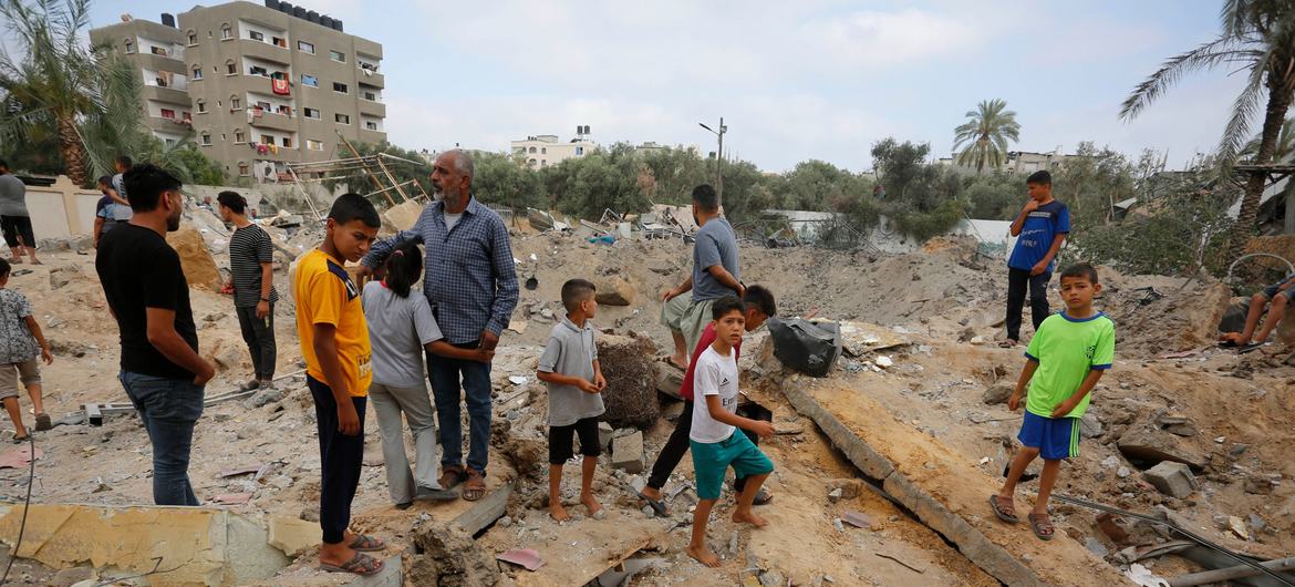 Hombres y niños observan el cráter de una bomba en Gaza.