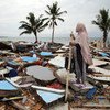 Una mujer observa su pueblo en Indonesia, destruido por un tsunami.