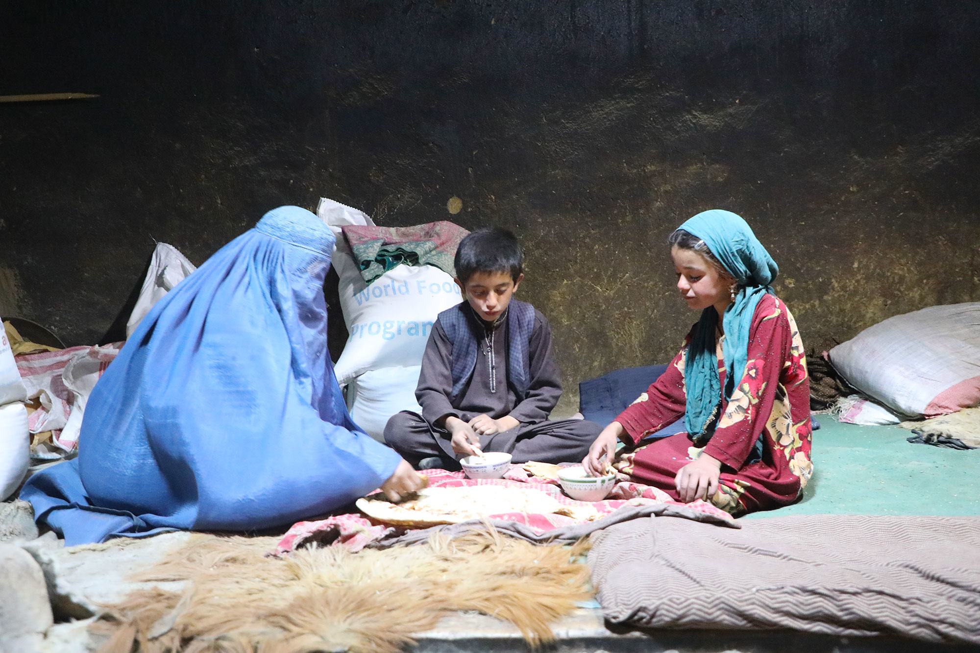 عائلة أفغانية تتناول طعاما حصلت عليه من الأمم المتحدة.
