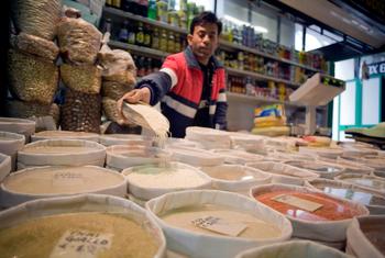 Un commerçant organise son stock de riz et de haricots sur un marché de Rome, en Italie.