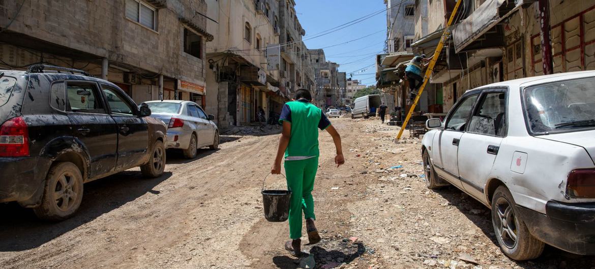 A person carries water through the streets in a West Bank town. The situation there is gradually worsening. 