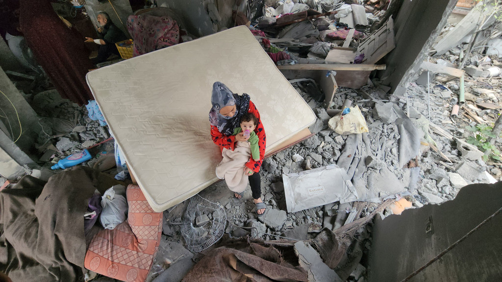 Une mère avec son nouveau-né dans les décombres de leur maison bombardée à Khan Younis (photo d'archives).