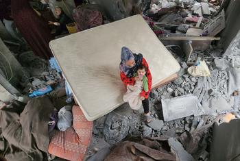 A mother with her newborn on the rubble of their bombed home in Khan Younis. (file)