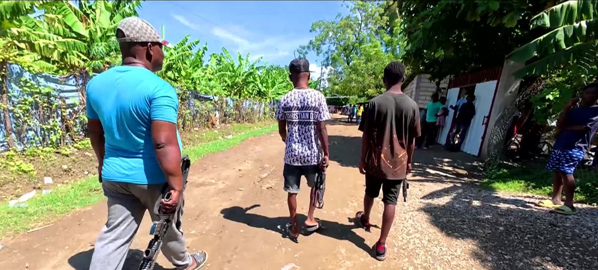 Armed gang members walk through a neighbourhood of Port-au-Prince