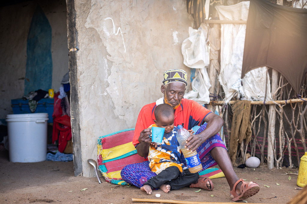 A man gives his grandson a drink of water amid a drought in Kenya. (file)