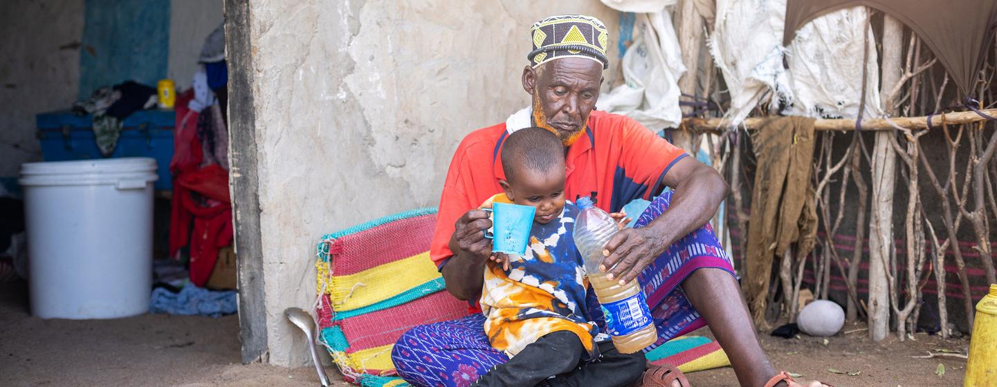 A man gives his grandson a drink of water amid a drought in Kenya. (file) A man gives his grandson a drink of water amid a drought in Kenya. (file)