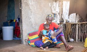 A man gives his grandson a drink of water amid a drought in Kenya. (file)