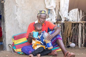 A man gives his grandson a drink of water amid a drought in Kenya. (file)