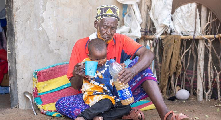 A man gives his grandson a drink of water amid a drought in Kenya. (file)