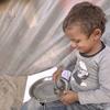 Un niño pequeño recoge los últimos granos de arroz de su cuenco. El hambre se dispara en Gaza y los alimentos del PMA autorizados a entrar son limitados