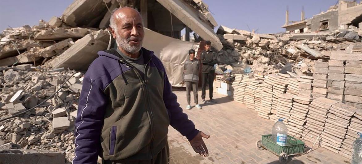 Abu Bilal shows his precarious shelter, built under two concrete slabs from his former apartment building.