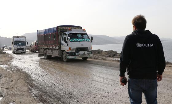 一名联合国工作人员在叙利亚北部观察援助物资的分发情况。