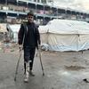 A young man stands close to temporary shelters in Gaza.