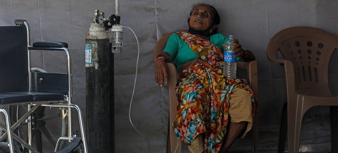 भारत के मुम्बई शहर के गोरेगाँव इलाक़े में एक मरीज़, चिकित्सा मदद की प्रतीक्षा करते हुए. इस मरीज़ को कोविड-19 का संक्रमण होने की भी आशंका है. भारत में अप्रैल 2021 में महामारी की स्थिति भीषण हो गई.