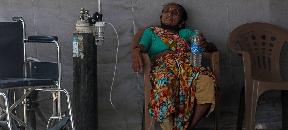 A patient who may have COVID-19 waits for medical assistance at a facility in the Goregaon area of Mumbai, India.