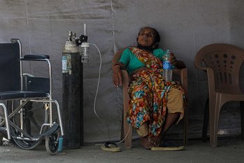 भारत के मुम्बई शहर के गोरेगाँव इलाक़े में एक मरीज़, चिकित्सा मदद की प्रतीक्षा करते हुए. इस मरीज़ को कोविड-19 का संक्रमण होने की भी आशंका है. भारत में अप्रैल 2021 में महामारी की स्थिति भीषण हो गई.
