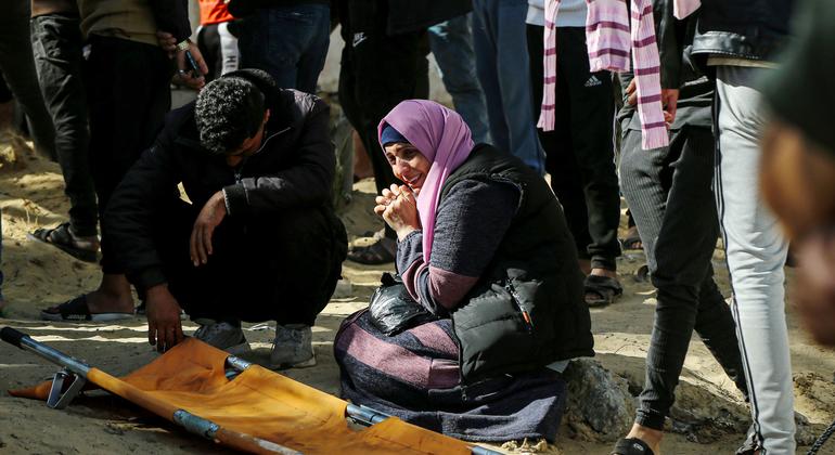 Palestinos em Khan Younis enterram seus mortos em sepulturas improvisadas.