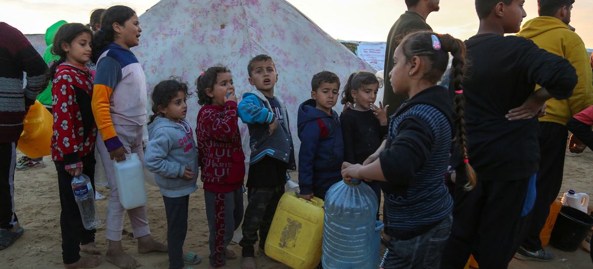 Des enfants palestiniens font la queue avec des récipients vides pour recevoir de l'eau à un point de distribution du camp de réfugiés de Rafah, dans la bande de Gaza.