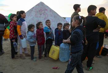 Des enfants palestiniens font la queue avec des récipients vides pour recevoir de l'eau à un point de distribution du camp de réfugiés de Rafah, dans la bande de Gaza.