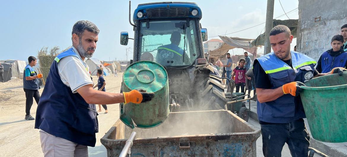 Trabajadores de UNRWA recogiendo basura para reducir el riesgo de que se propaguen enfermedades infecciosas.