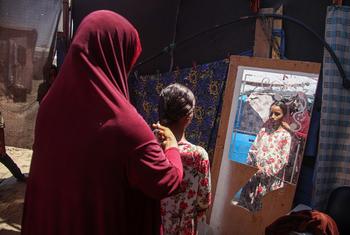 A mother and daughter shelter at a displacement camp in Gaza. In overcrowded conditions with no privacy, women and girls struggle to manage their menstruation.