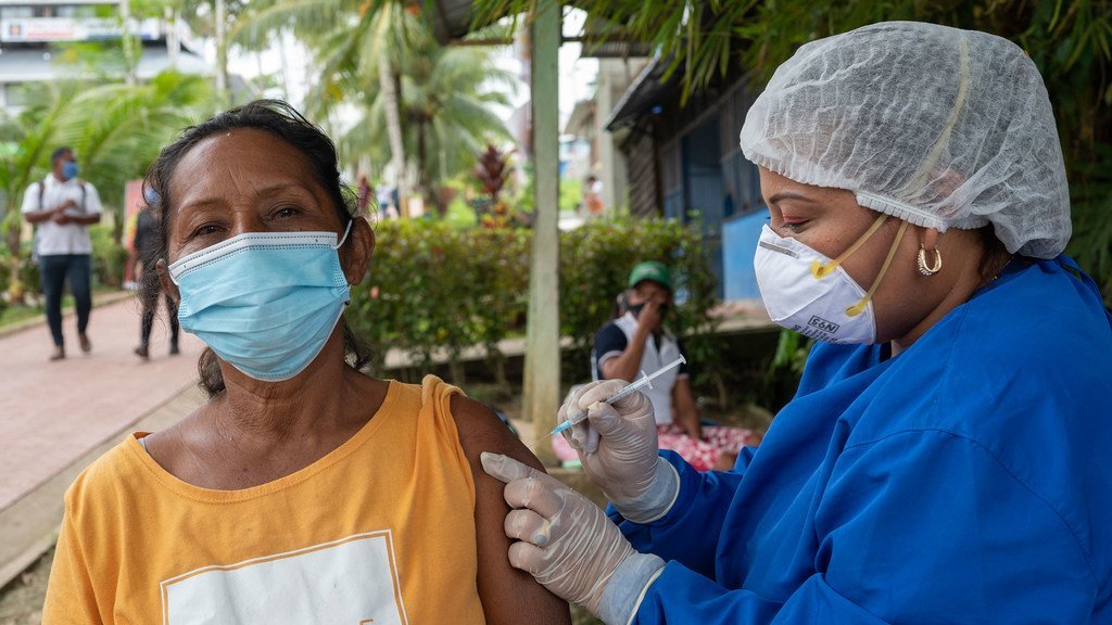 Una mujer indígena recibe la vacuna contra el COVID-19 en Colombia.