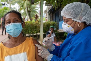 Una mujer indígena recibe la vacuna contra el COVID-19 en Colombia.