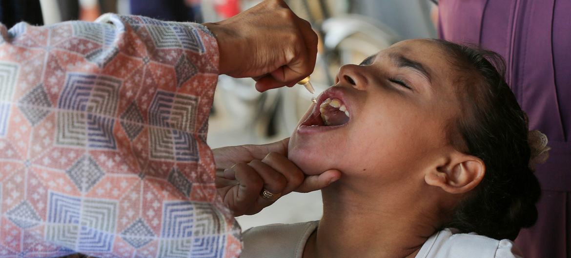 A polio vaccine is administered to a child in Gaza, a campaign supported by WHO.