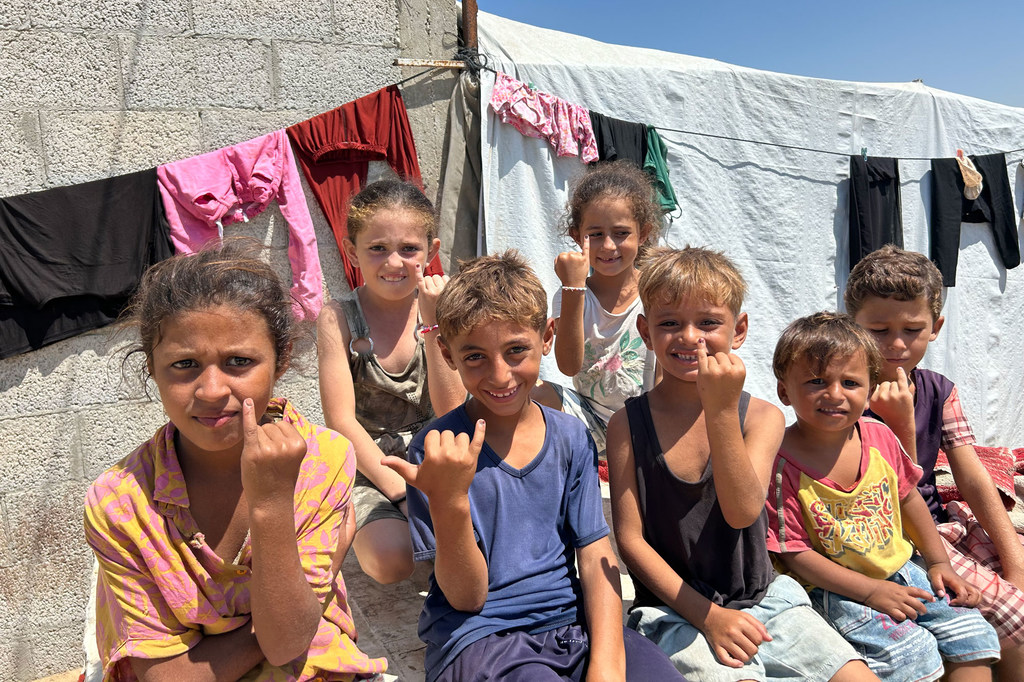 De jeunes enfants à Gaza montrent leurs doigts encrés indiquant qu'ils ont été vaccinés contre la polio.