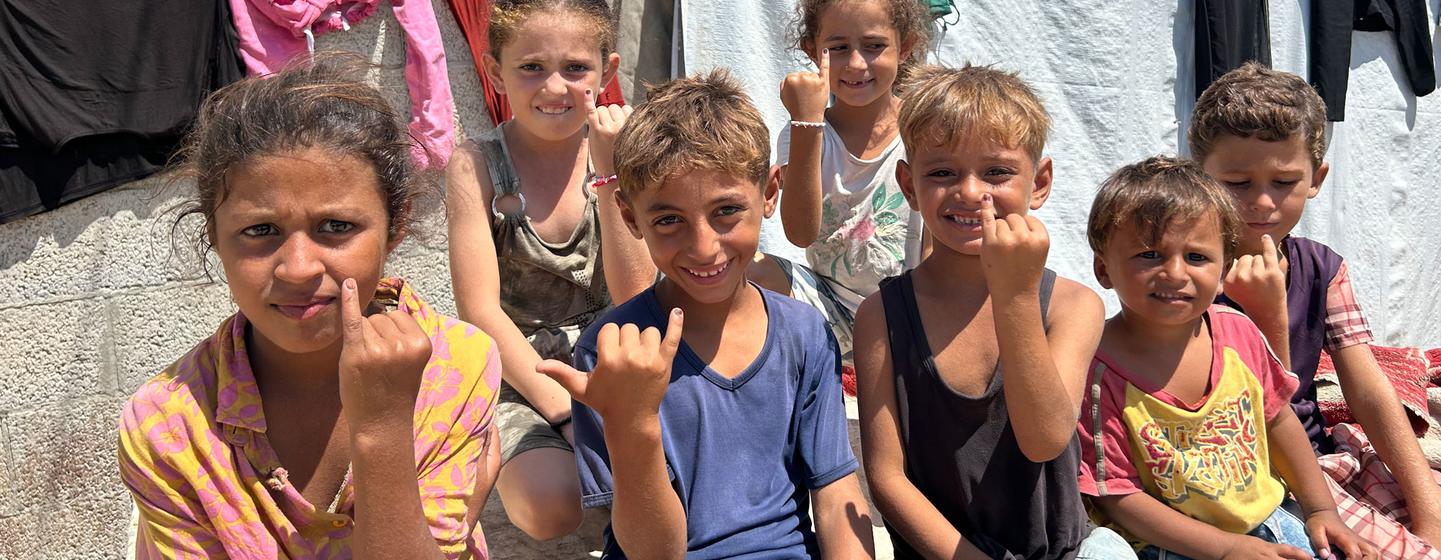 De jeunes enfants à Gaza montrent leurs doigts encrés indiquant qu'ils ont été vaccinés contre la polio.