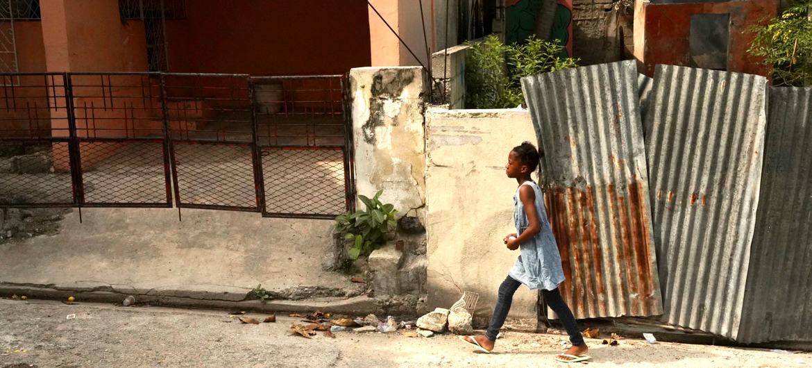 Uma jovem caminha na capital do Haiti, Porto Príncipe