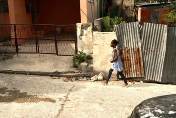 Uma jovem caminha na capital do Haiti, Porto Príncipe