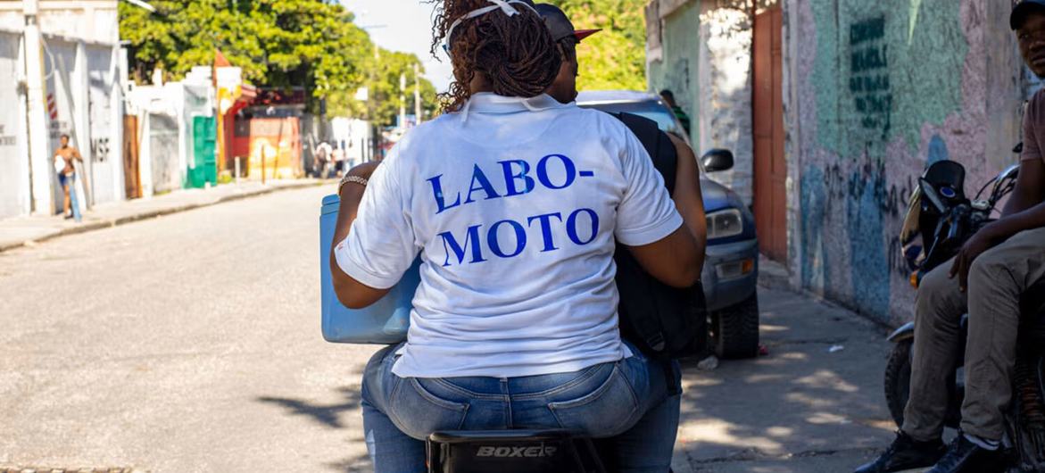 Un trabajador sanitario «labo moto» se desplaza en motocicleta para visitar a un paciente.