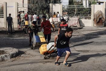 Children collect water in Khan Younis city, in the southern Gaza Strip.