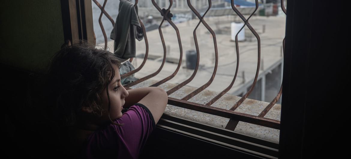 Una niña palestina mira por la ventana de su habitación en la Franja de Gaza.
