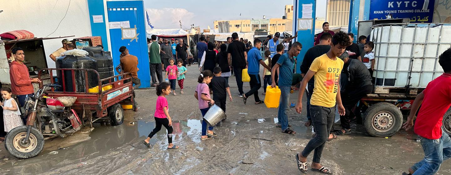 أشخاص نزحوا بسبب الصراع في غزة يجلبون المياه في مخيم خان يونس للاجئين.
