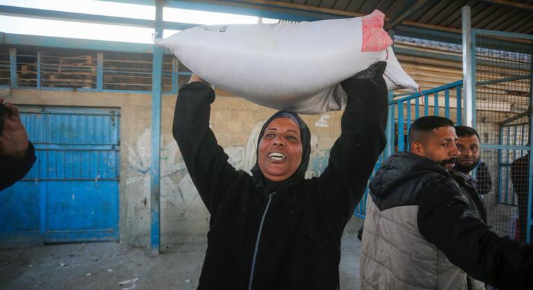 Una mujer lleva harina distribuida por UNRWA en Gaza.