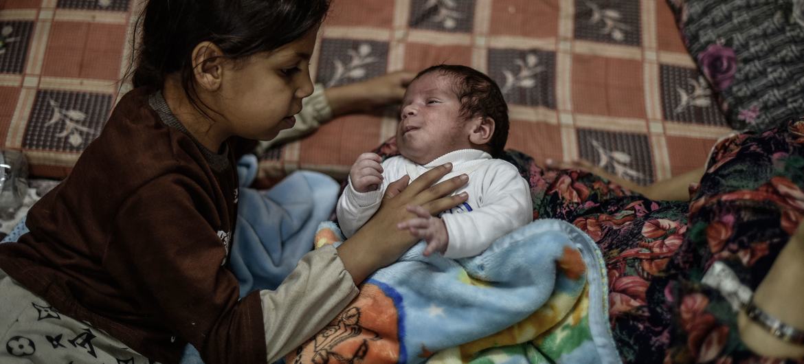 Una niña cuida de su hermana pequeña en un refugio de Khan Younis, en el sur de la Franja de Gaza. (archivo)
