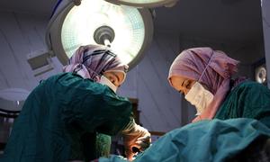 Medical workers perform an emergency operation at the Idlib Maternity Hospital in Syria. 