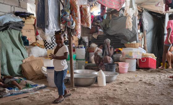 在太子港的一所学校里，因暴力冲突而流离失所的家庭在拥挤且卫生条件恶劣的环境中栖身。