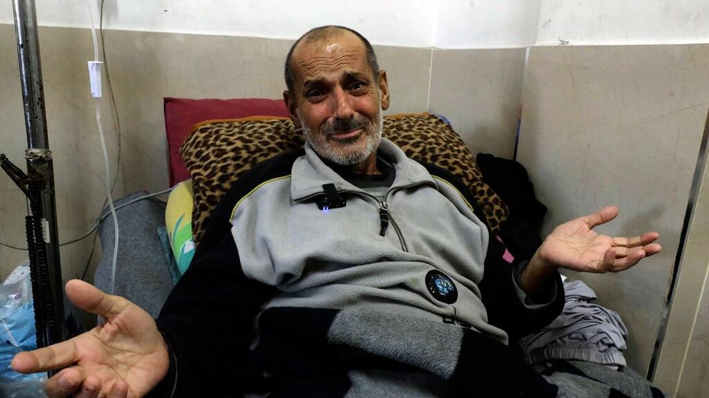 Mundhir Abu Foul, un patient atteint d'un cancer à Gaza, est assis sur un lit d'hôpital avec les mains ouvertes, semblant parler ou faire des gestes.