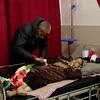 Un patient âgé atteint d'un cancer est allongé dans un lit d'hôpital à Gaza, assisté par un soignant.