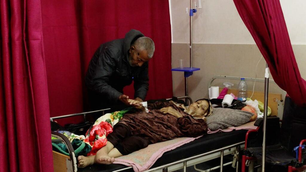 Un homme prend soin de sa mère âgée, atteinte d'un cancer, à l'hôpital Al-Shifa de Gaza