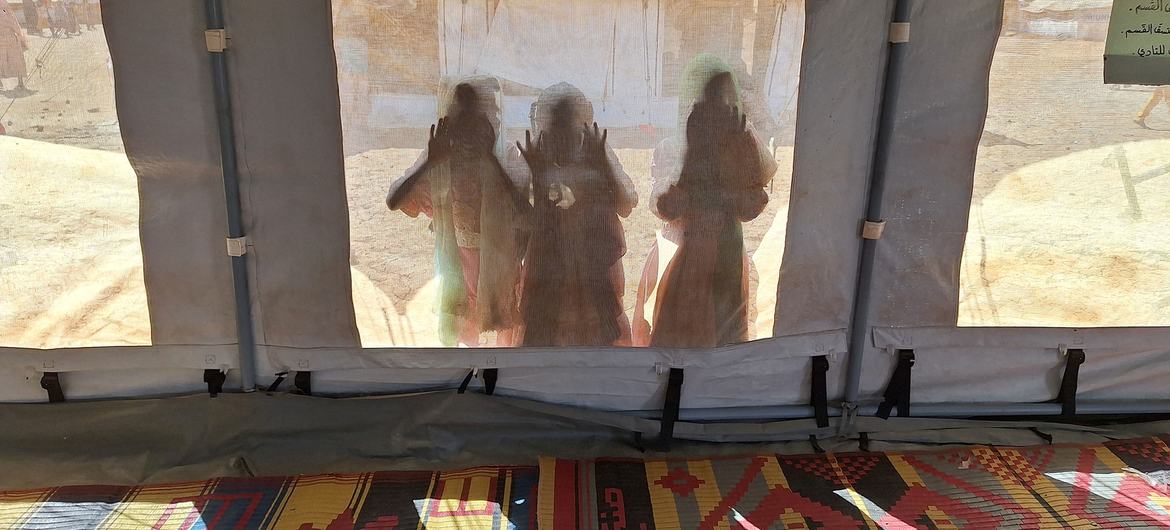 ? UNICEF/Tess Ingram Children peer through a UNICEF tent at a child-friendly space in Kassala state, Sudan.
