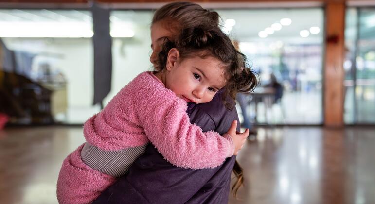 Мать держит близко своего маленького ребенка в государственной школе в Маунт-Ливан, Ливан, в рамках неотложной помощи ЮНИСЕФ перемещенным семьям, ищущим убежища.