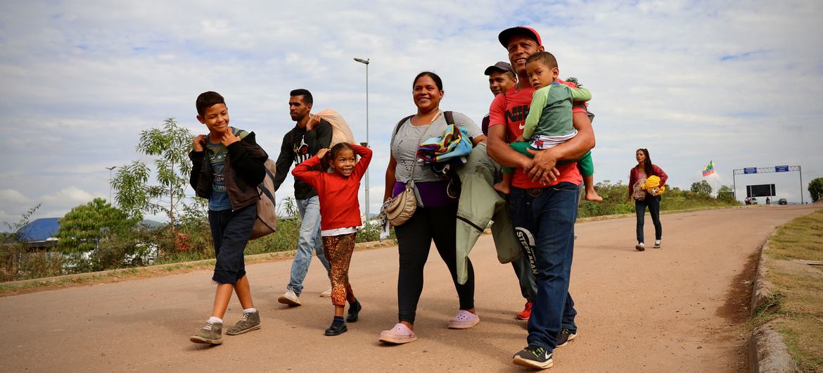 ایک خاندان پیدل چل کر وینزویلا سے برازیل کی سرحد عبور کر رہا ہے۔