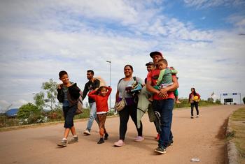 ایک خاندان پیدل چل کر وینزویلا سے برازیل کی سرحد عبور کر رہا ہے۔