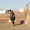 Une femme porte de l'eau dans le camp pour personnes déplacées d'Al Houri, dans l'État de Gedaref, au Soudan.