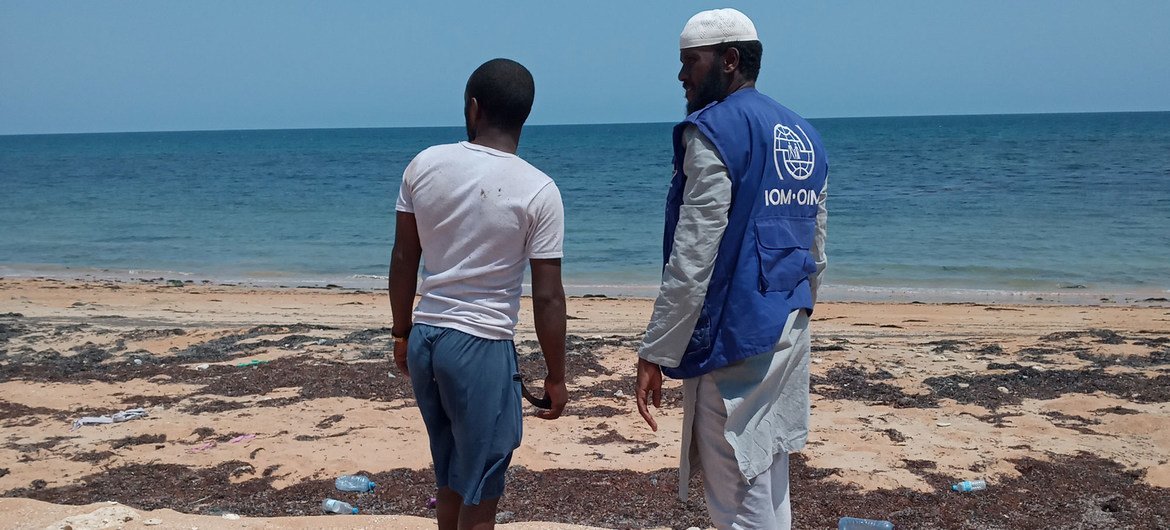 A staff member of the IOM in Djibouti talks to a migrant who arrived in the African country by boat.